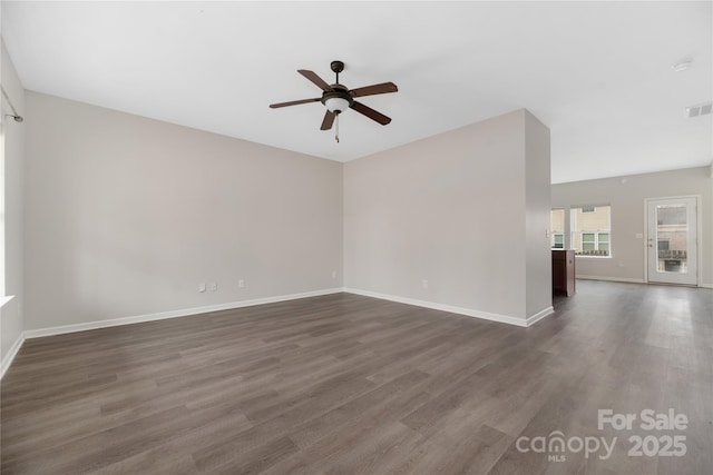 spare room featuring dark wood-type flooring and ceiling fan