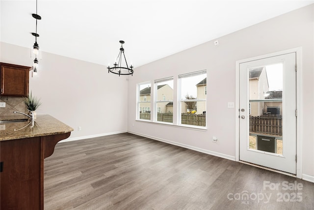 unfurnished dining area featuring plenty of natural light, sink, and hardwood / wood-style floors