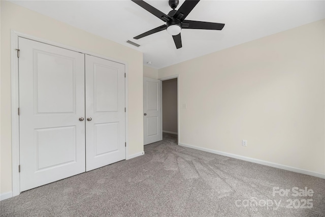 unfurnished bedroom with light colored carpet, a closet, and ceiling fan