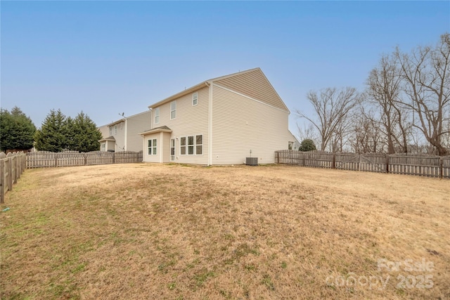 rear view of house featuring a lawn and central air condition unit