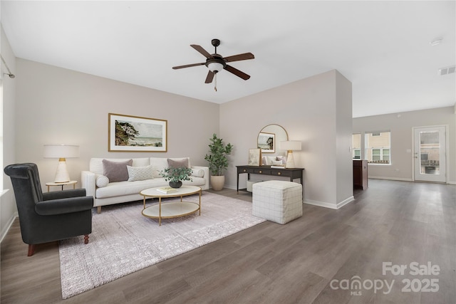 living room featuring dark wood-type flooring and ceiling fan