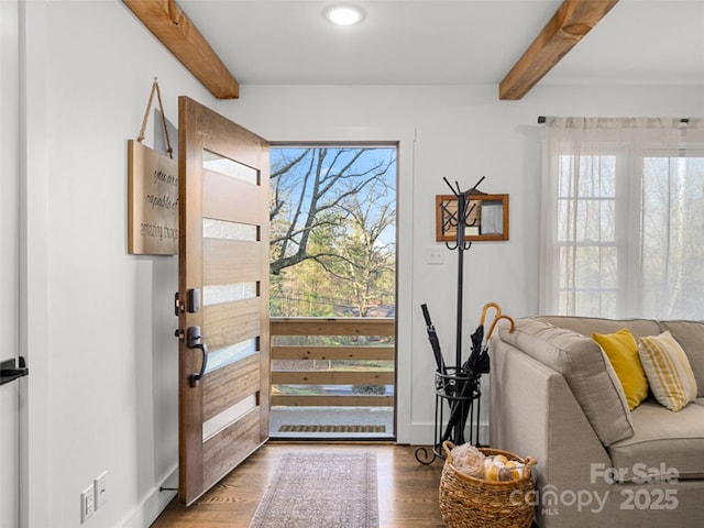 foyer entrance with wood-type flooring, plenty of natural light, and beamed ceiling