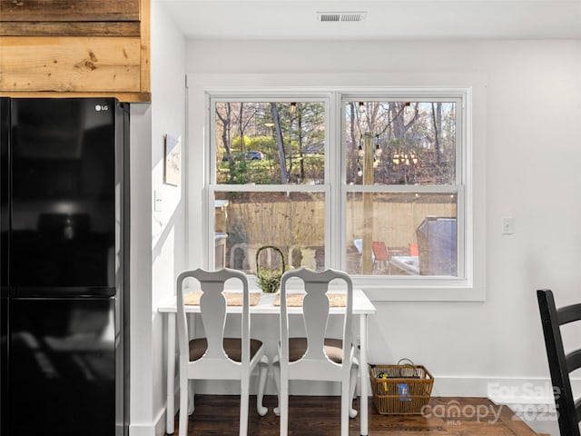 dining space with plenty of natural light and dark hardwood / wood-style floors