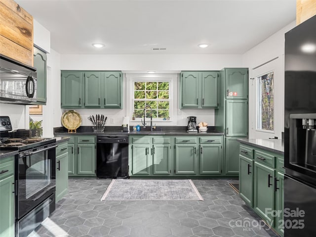 kitchen featuring sink, black appliances, and green cabinetry