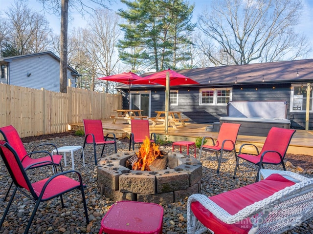 view of patio with a jacuzzi, a wooden deck, and an outdoor fire pit