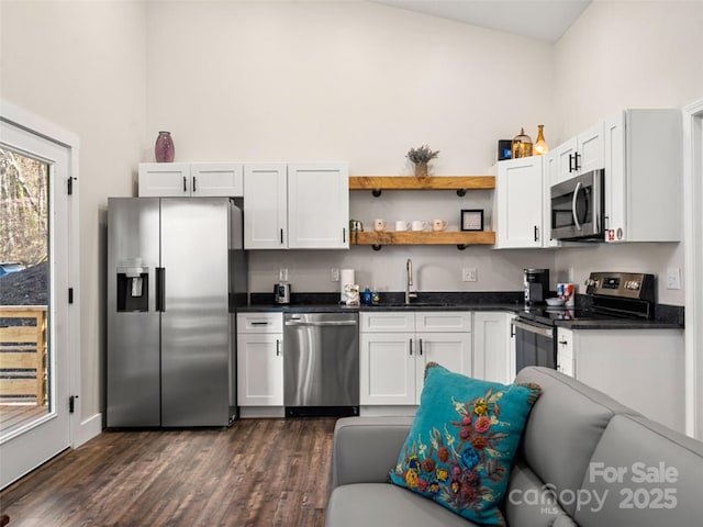 kitchen featuring appliances with stainless steel finishes, dark hardwood / wood-style flooring, white cabinetry, and sink