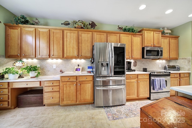 kitchen with decorative backsplash, light tile patterned floors, and stainless steel appliances