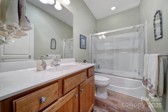 full bathroom featuring hardwood / wood-style flooring, vanity, toilet, and enclosed tub / shower combo