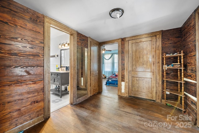 interior space with dark hardwood / wood-style flooring and wooden walls