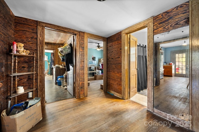 hall with wood walls and light hardwood / wood-style floors