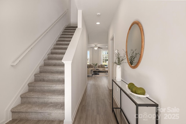 stairs with ceiling fan and wood-type flooring