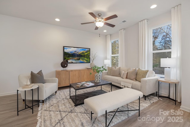 living room featuring ceiling fan, a healthy amount of sunlight, and light hardwood / wood-style flooring