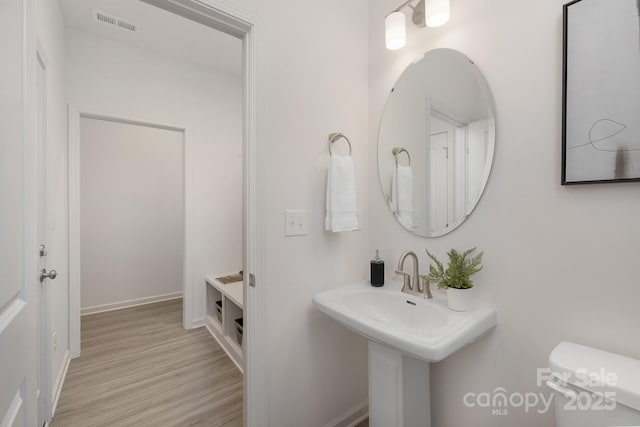 bathroom with hardwood / wood-style flooring and toilet