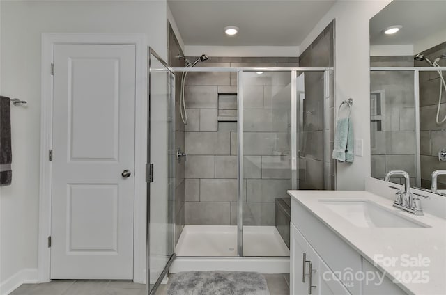 bathroom featuring tile patterned flooring, vanity, and a shower with shower door