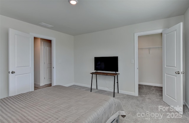 unfurnished bedroom featuring light colored carpet, a spacious closet, and a closet