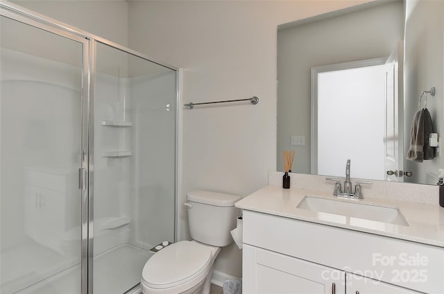 bathroom featuring vanity, an enclosed shower, and toilet