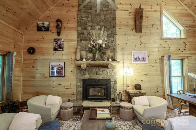 living room with high vaulted ceiling, plenty of natural light, wooden ceiling, and wood walls