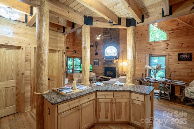 kitchen featuring light wood-type flooring, a wood stove, and wooden walls