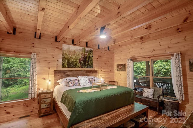 bedroom with wood walls, hardwood / wood-style floors, beamed ceiling, and wood ceiling