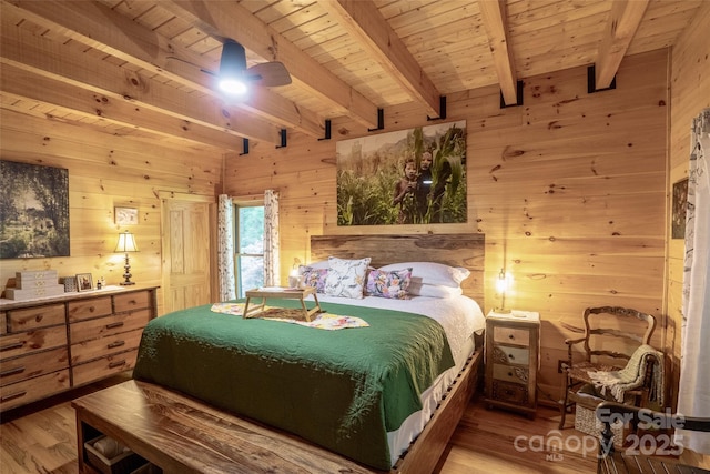 bedroom with beam ceiling, wood walls, wooden ceiling, and hardwood / wood-style flooring