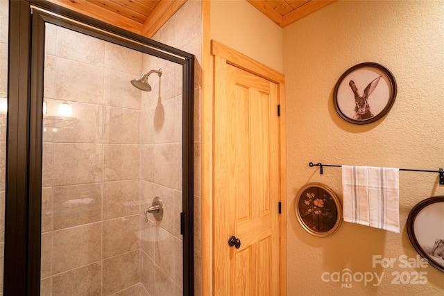 bathroom featuring wood ceiling and walk in shower