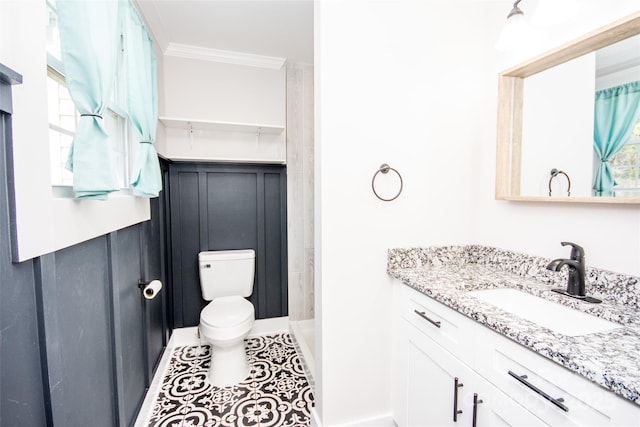 bathroom with tile patterned flooring, ornamental molding, vanity, and toilet