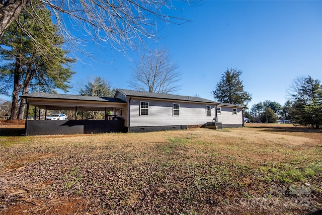 view of side of home featuring a carport and a lawn