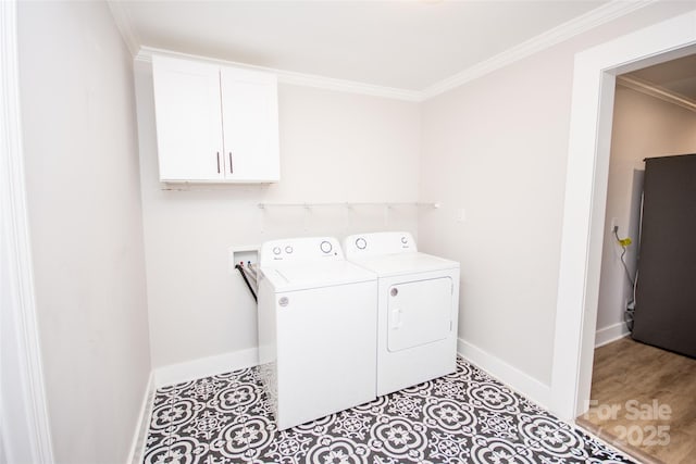 clothes washing area with cabinets, crown molding, and separate washer and dryer