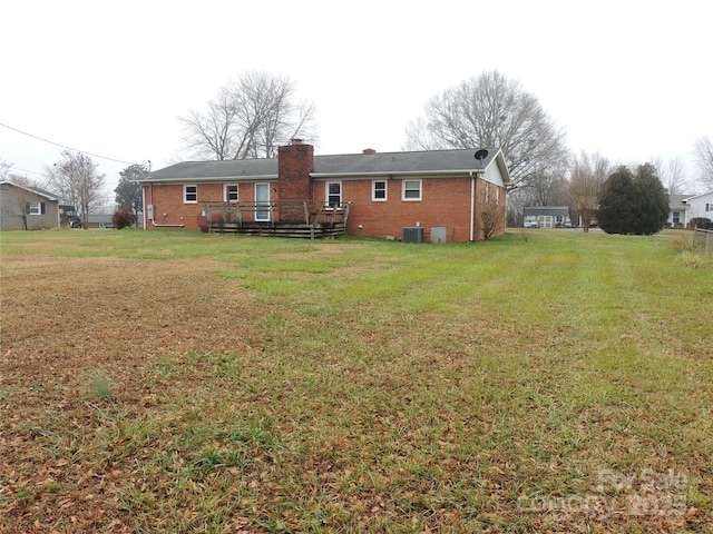 back of house with central AC unit, a yard, and a wooden deck