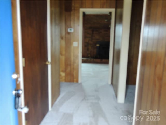 hallway featuring wooden walls