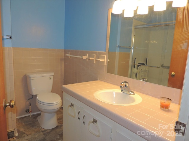 bathroom featuring tile walls, vanity, an enclosed shower, and toilet