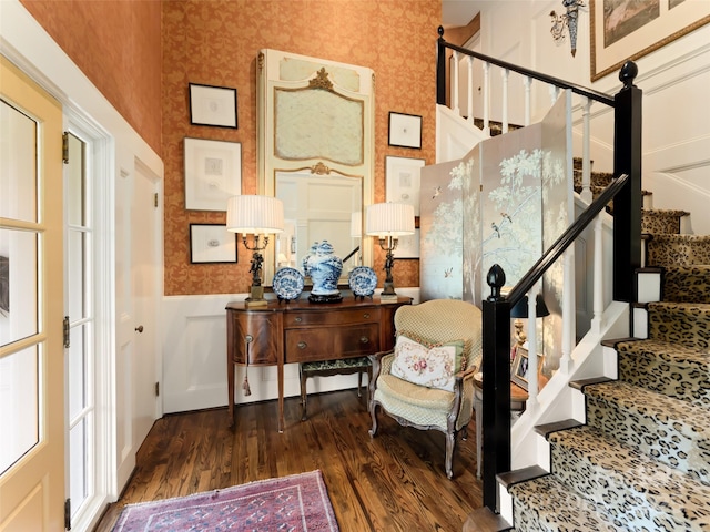 stairway featuring hardwood / wood-style flooring and a high ceiling