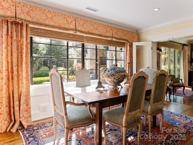 dining room with crown molding, plenty of natural light, and hardwood / wood-style flooring