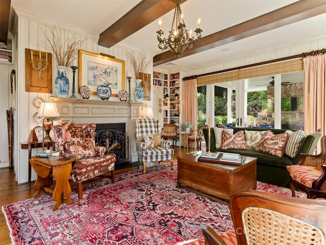 living area with beamed ceiling, ornamental molding, hardwood / wood-style floors, and an inviting chandelier