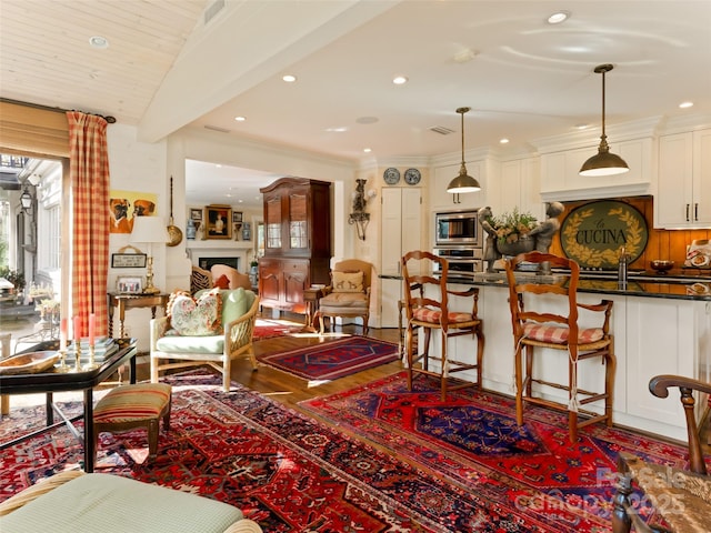 living room with hardwood / wood-style floors, beam ceiling, wood ceiling, and a fireplace