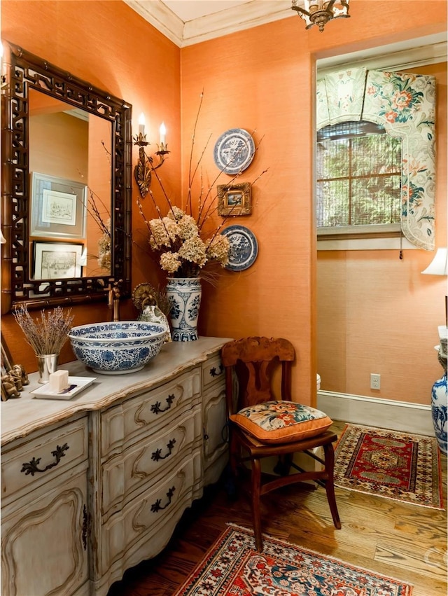 living area with hardwood / wood-style floors, crown molding, and sink