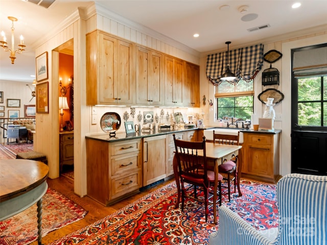 kitchen with decorative light fixtures, plenty of natural light, light wood-type flooring, and crown molding