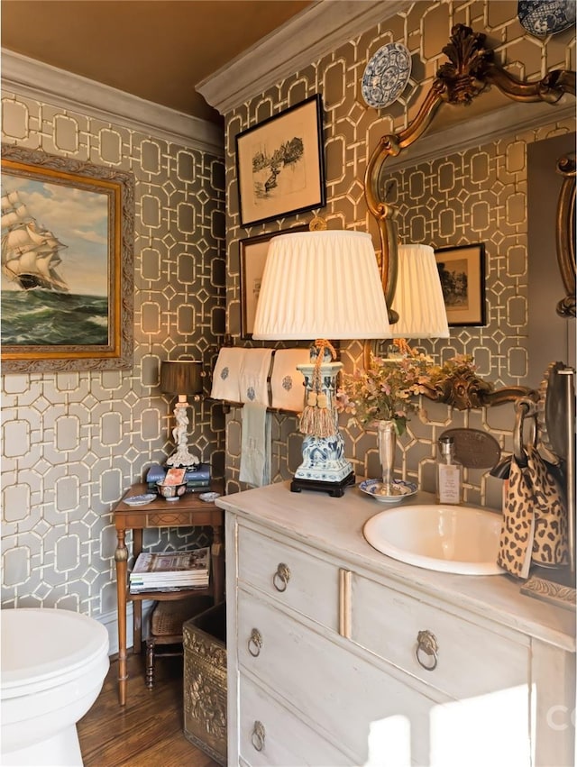 bathroom featuring vanity, hardwood / wood-style flooring, toilet, and crown molding