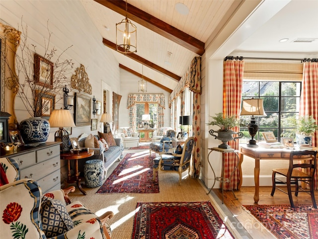 sitting room with beamed ceiling, hardwood / wood-style floors, high vaulted ceiling, and a chandelier