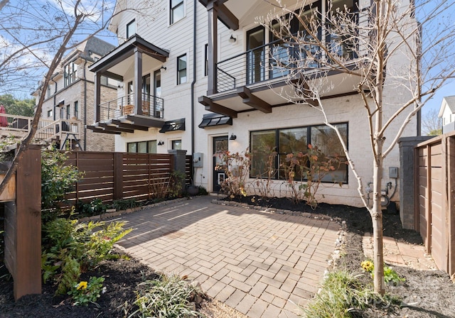 rear view of house with a patio area and a balcony