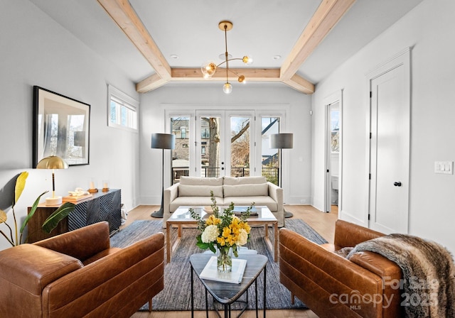 living room featuring a chandelier, light wood-type flooring, and lofted ceiling with beams