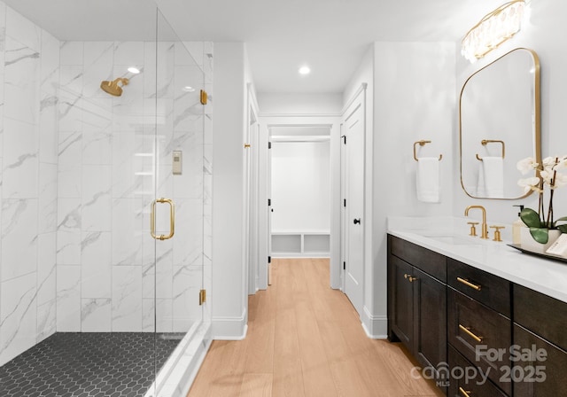 bathroom featuring hardwood / wood-style floors, vanity, and a shower with shower door