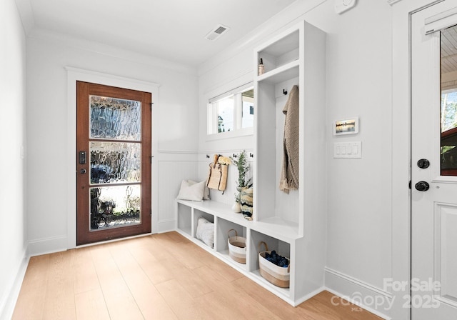 mudroom featuring a wealth of natural light, crown molding, and light hardwood / wood-style floors