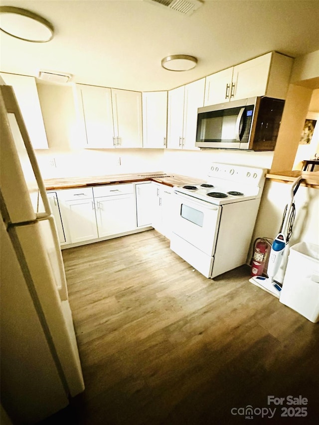 kitchen with white cabinets, light wood-type flooring, and white appliances