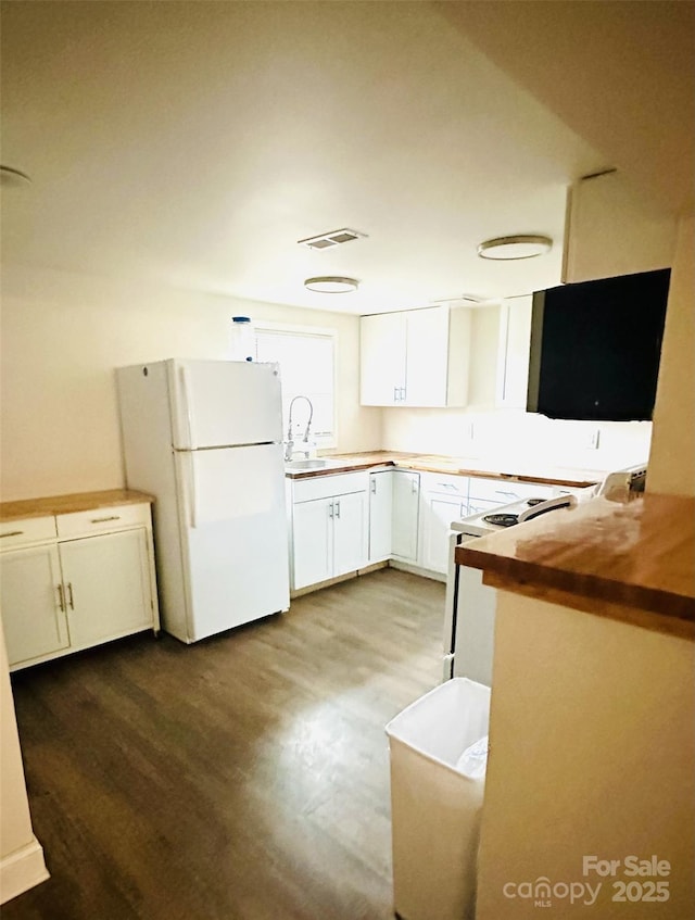 kitchen featuring white cabinetry, white refrigerator, butcher block countertops, hardwood / wood-style floors, and range