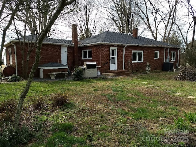 back of house featuring central AC and a yard