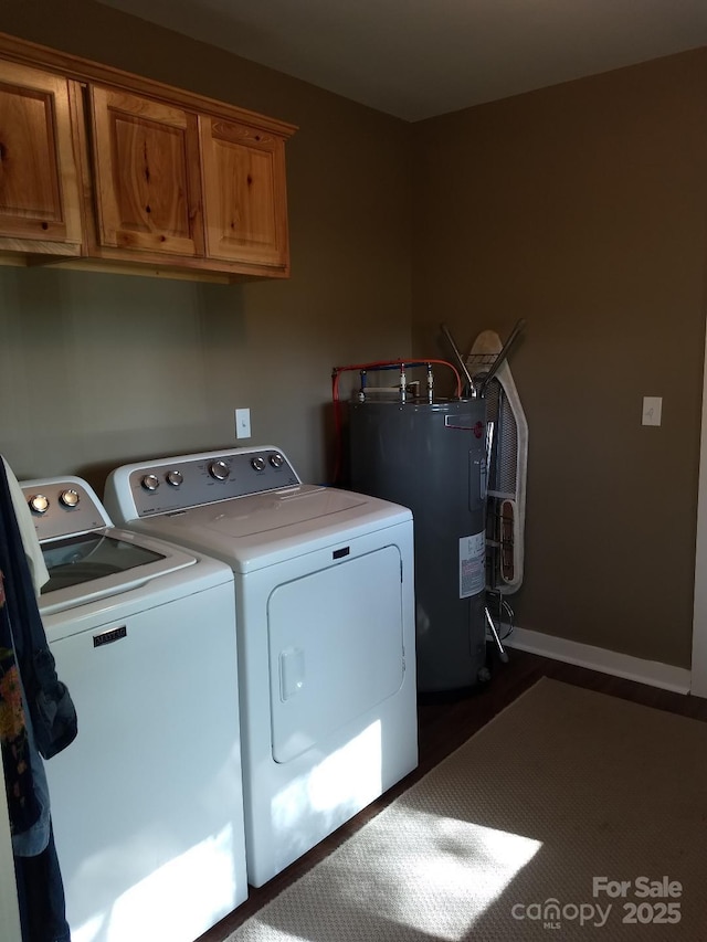 clothes washing area featuring cabinets, washing machine and dryer, and electric water heater