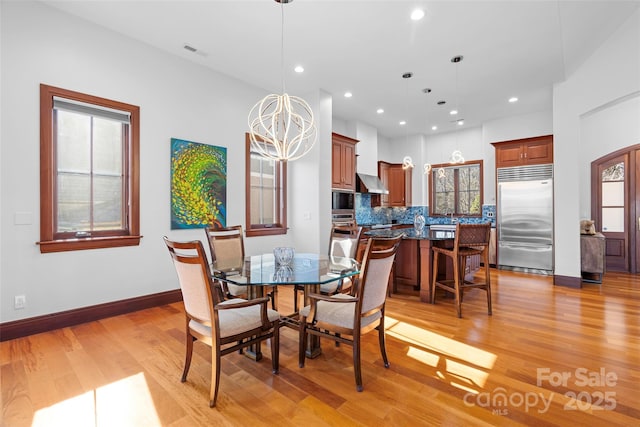 dining area featuring an inviting chandelier and light wood-type flooring