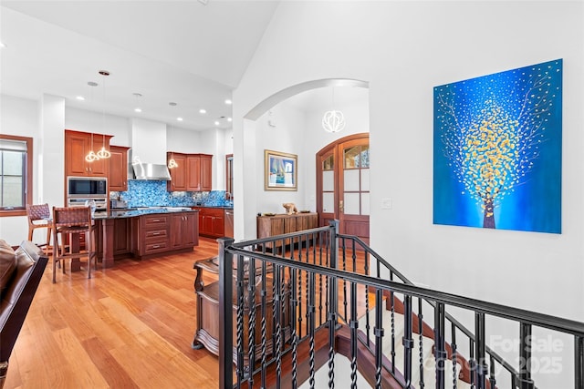 interior space with light hardwood / wood-style floors, french doors, high vaulted ceiling, and a chandelier