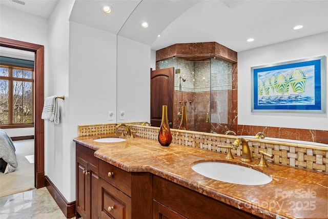 bathroom featuring vanity, tasteful backsplash, and a shower with shower door